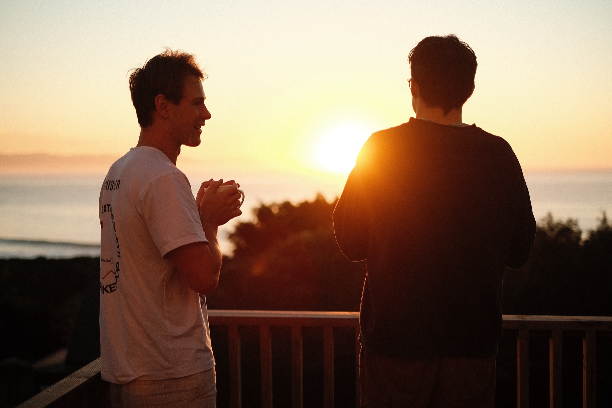 Two friends talking over coffee at sunset