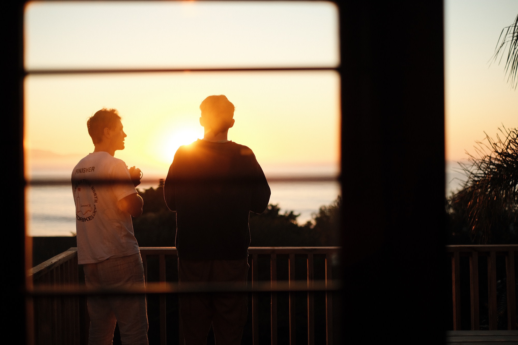 Two friends silhouetted against the evening sea