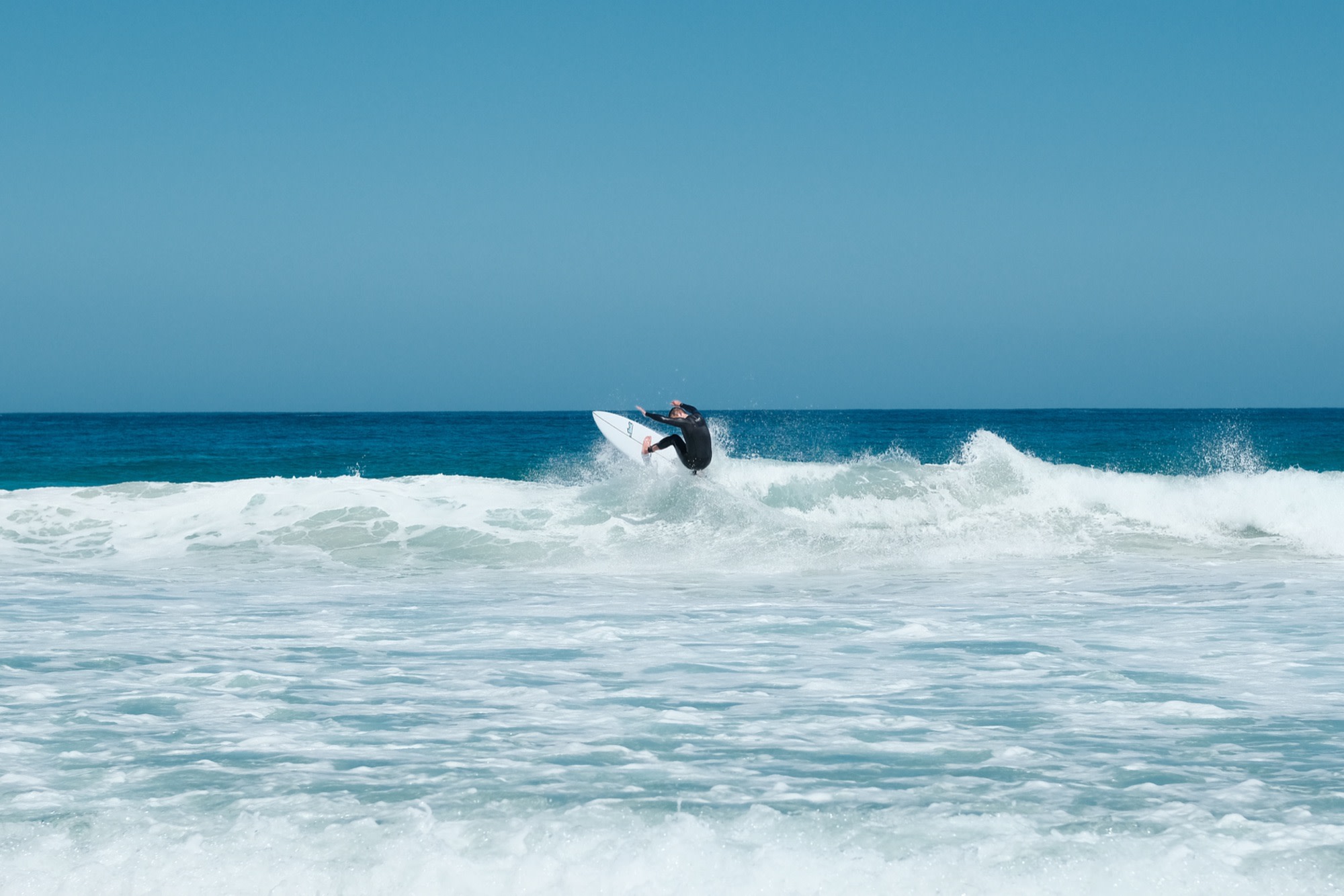 Laurence surfing a clean blue wave