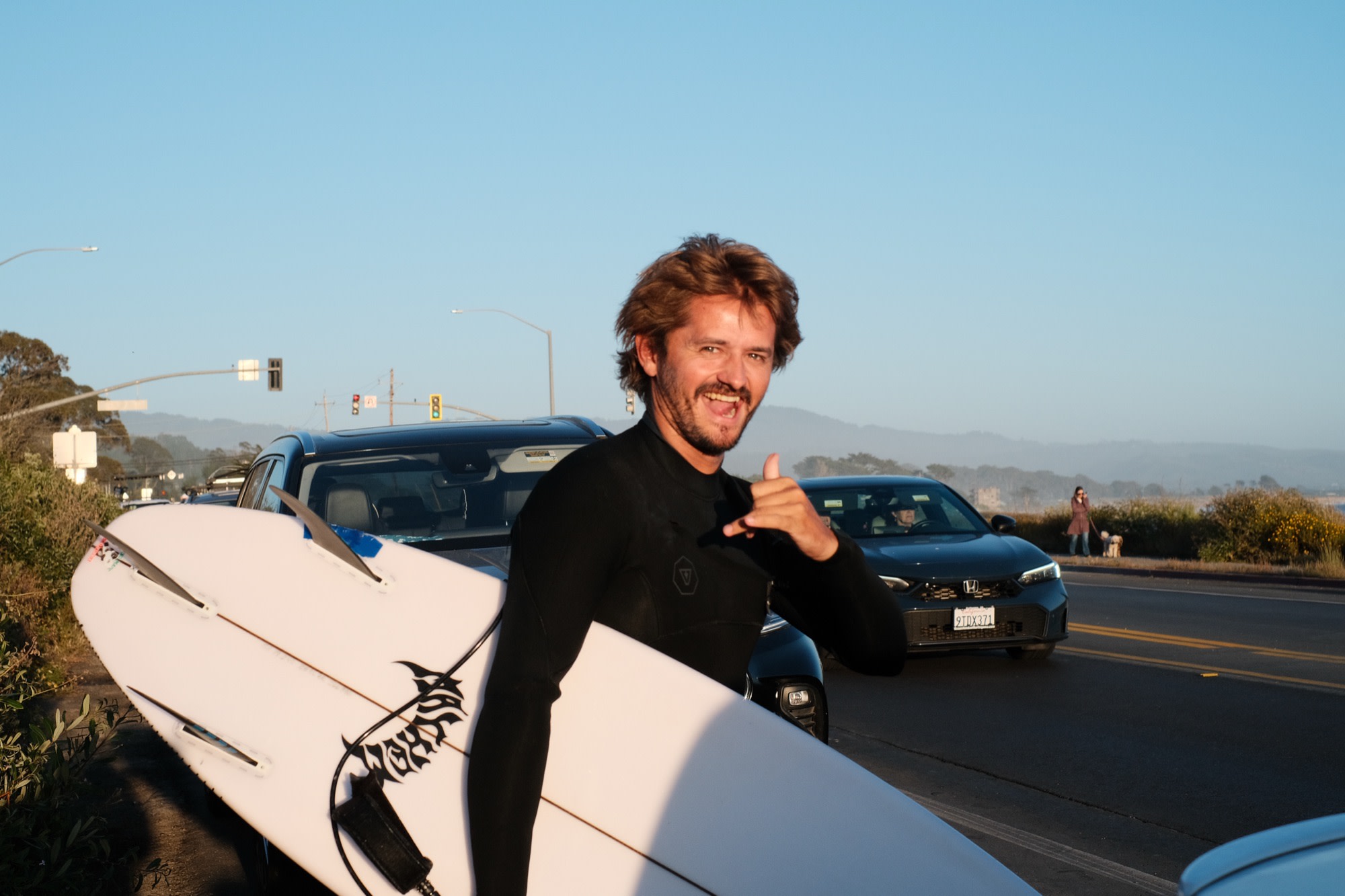 Laurence throwing a shaka on his way to surf