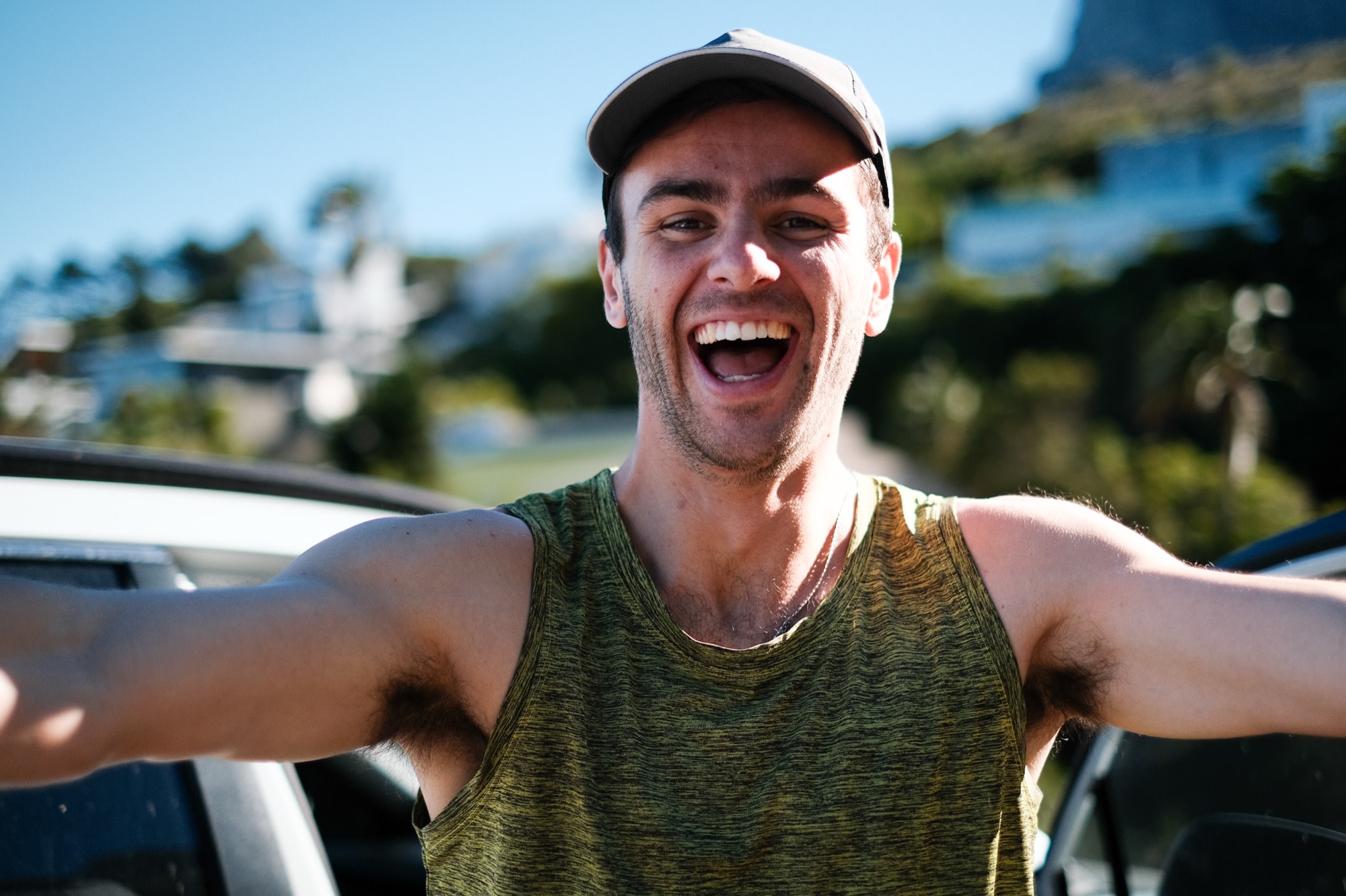 Mike laughing, arms wide, in the summer sun