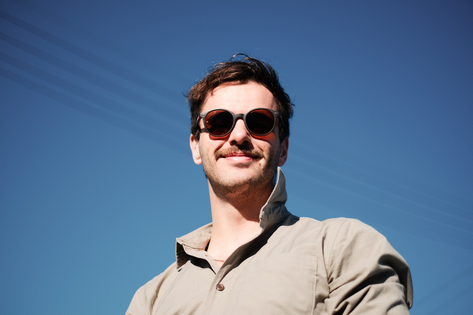 Mike in sunglasses against a bright blue sky