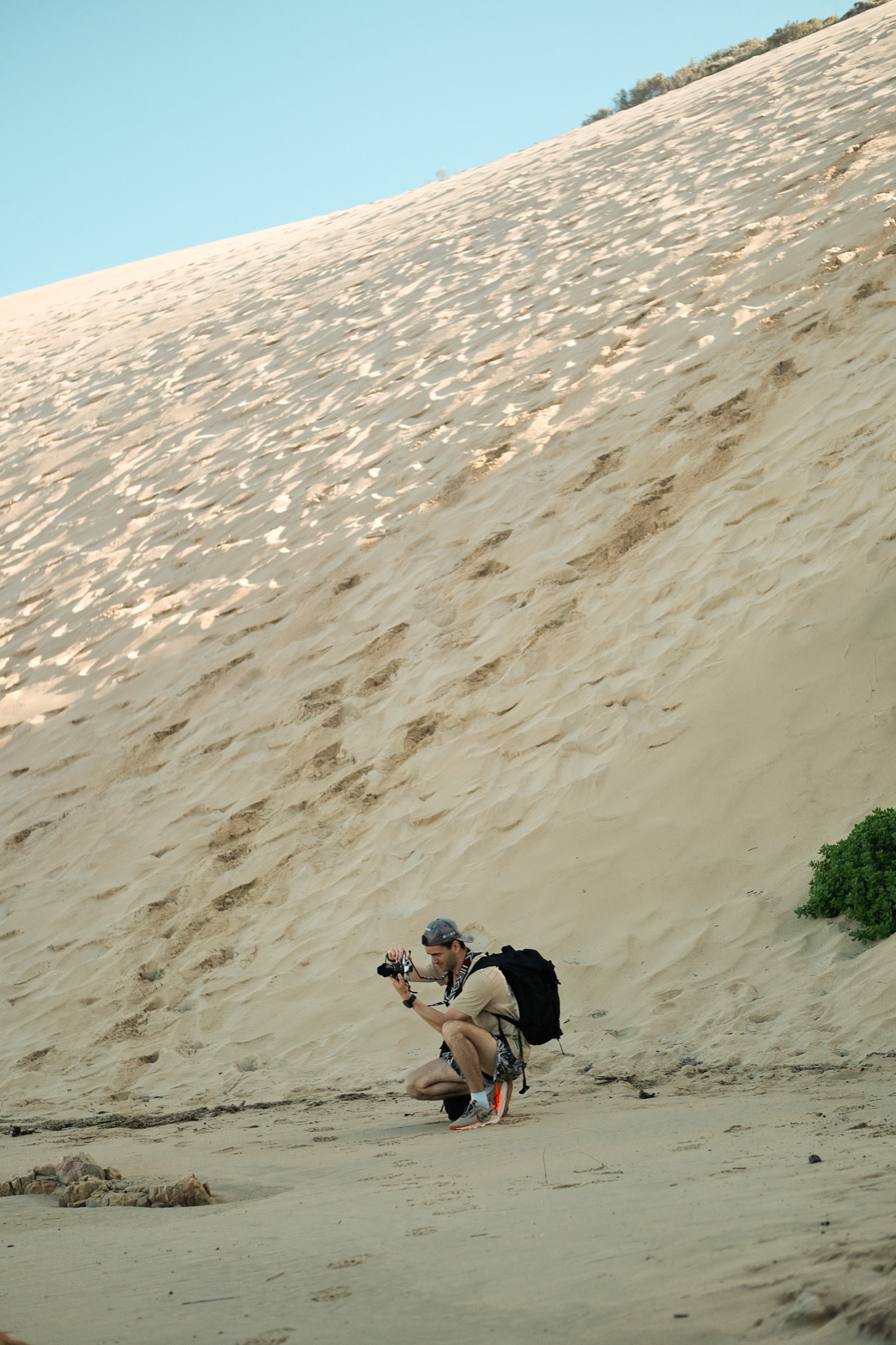 Mike crouched to shoot at the foot of a dune