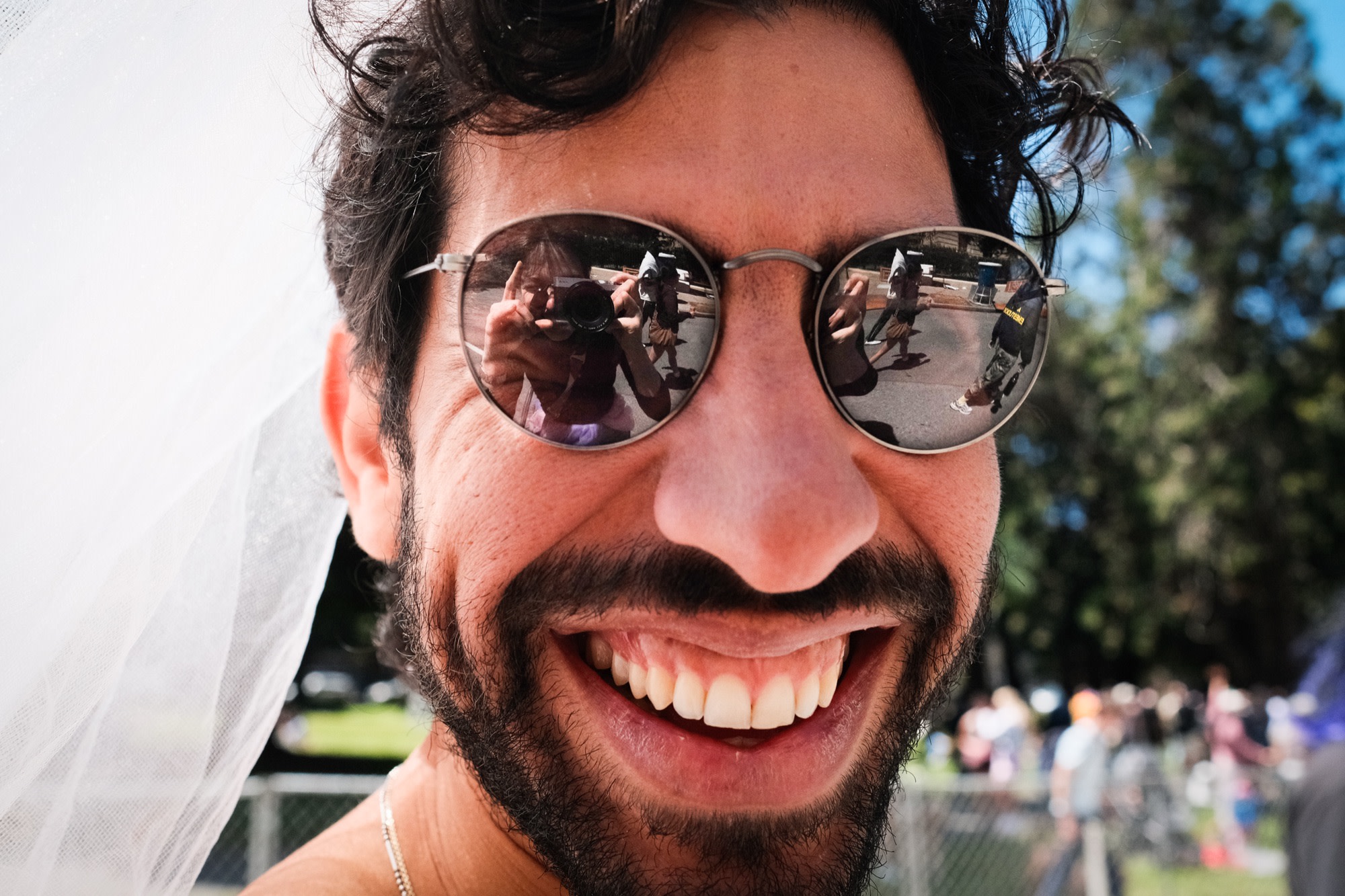 A close-up grin, the camera caught in the lenses