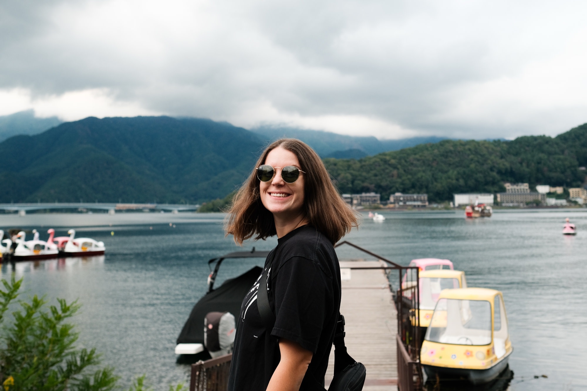A grin by the lake, swan pedal boats and misty mountains behind