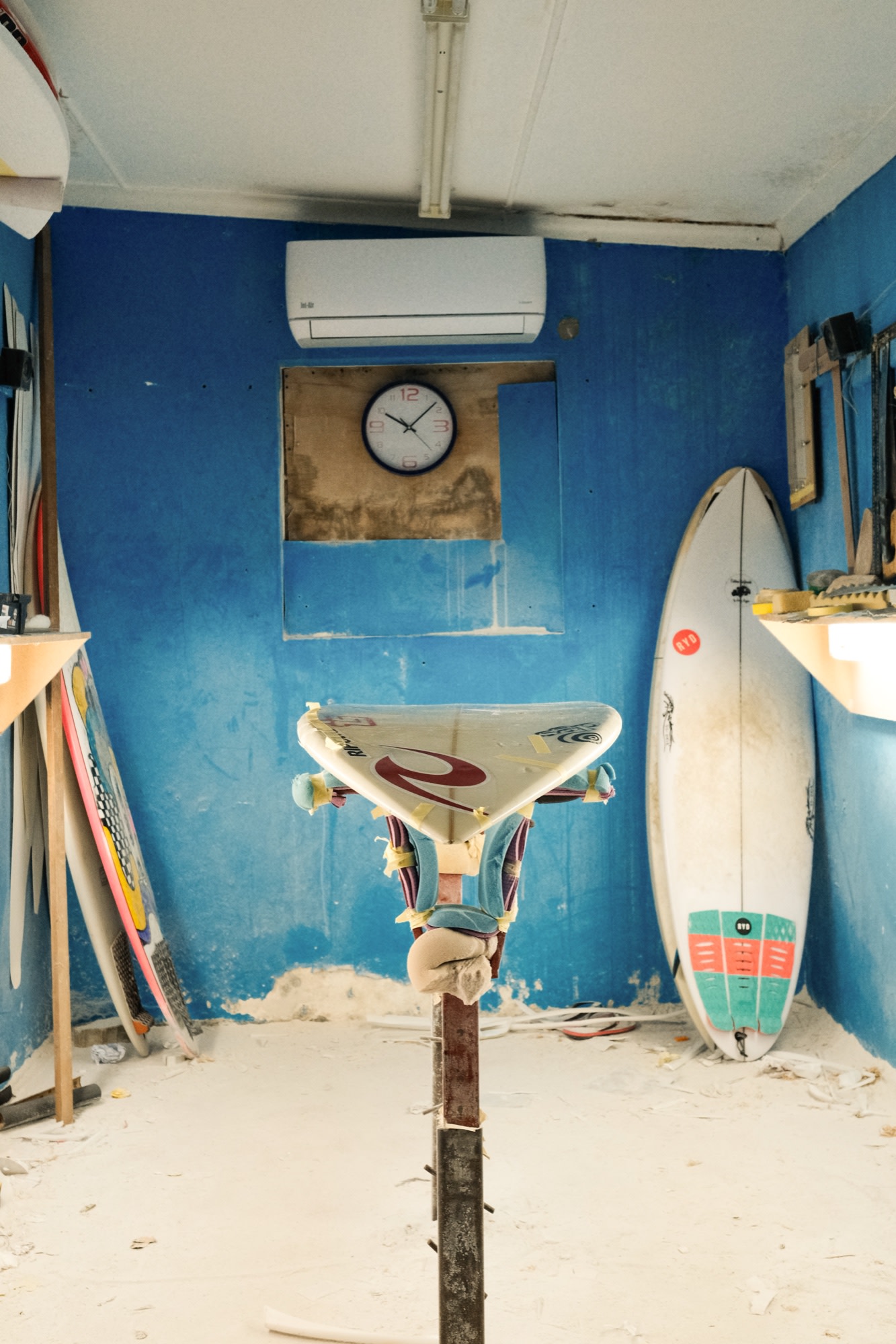 Surfboards in a shaper's blue workshop