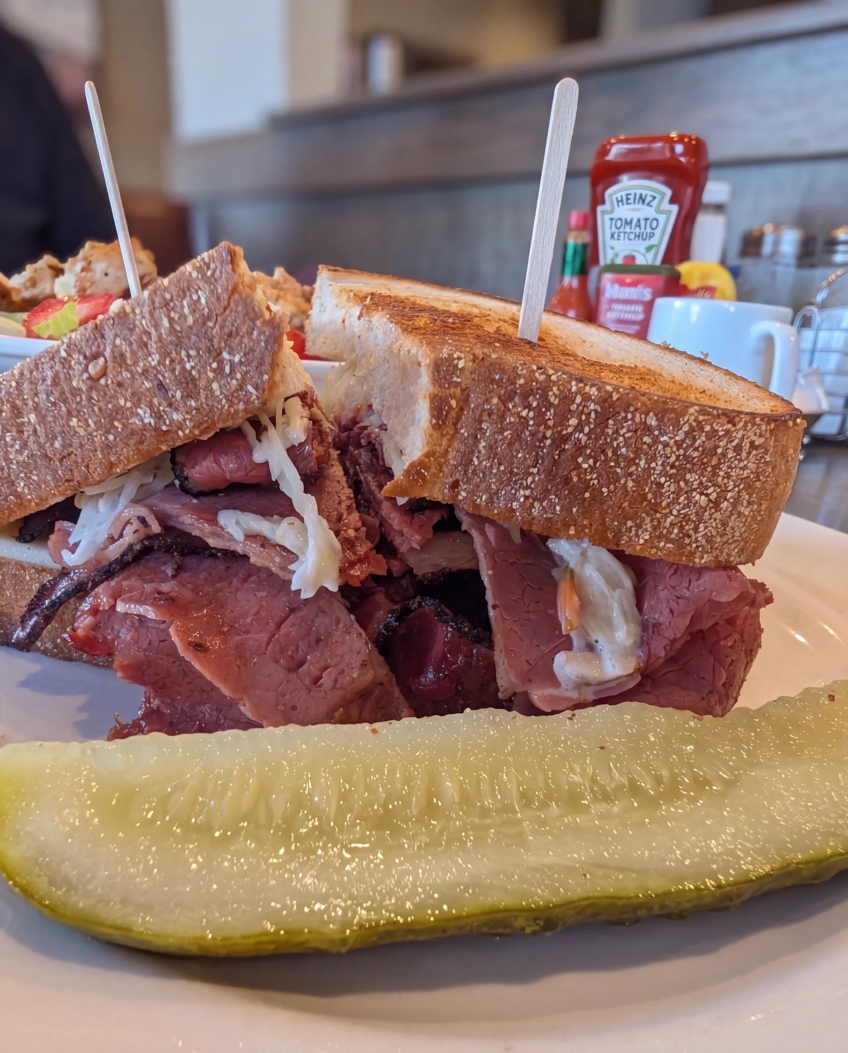 Corned beef and pastrami combo on rye with a pickle