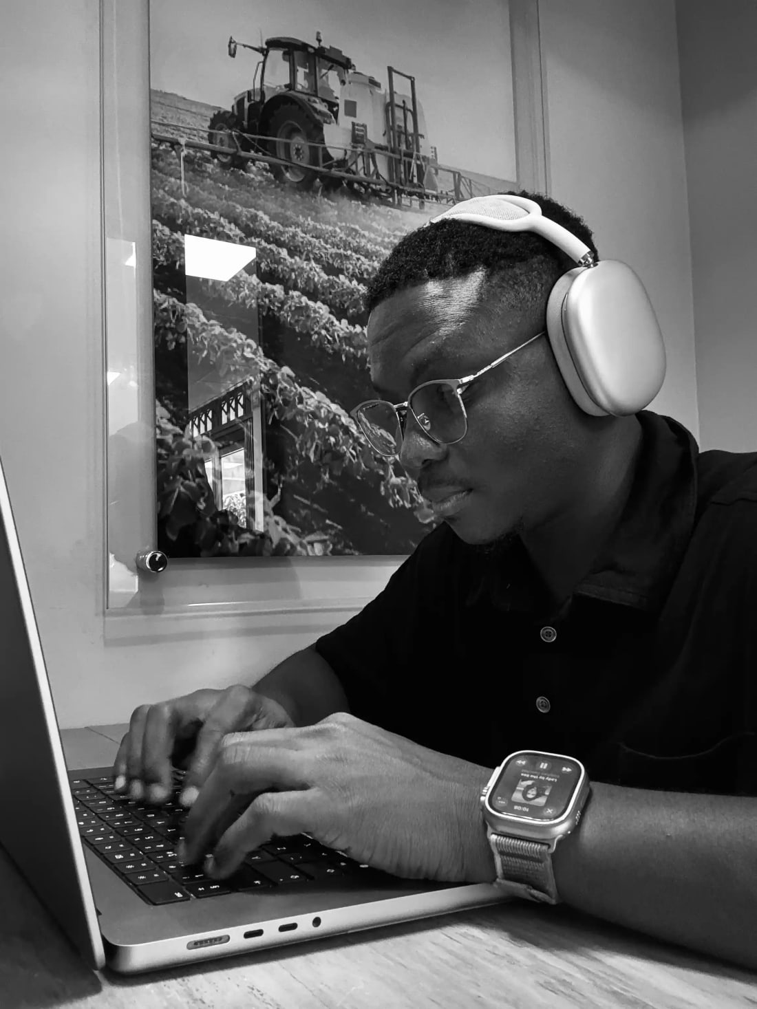 Felix Yeboah wearing headphones, working on a laptop
