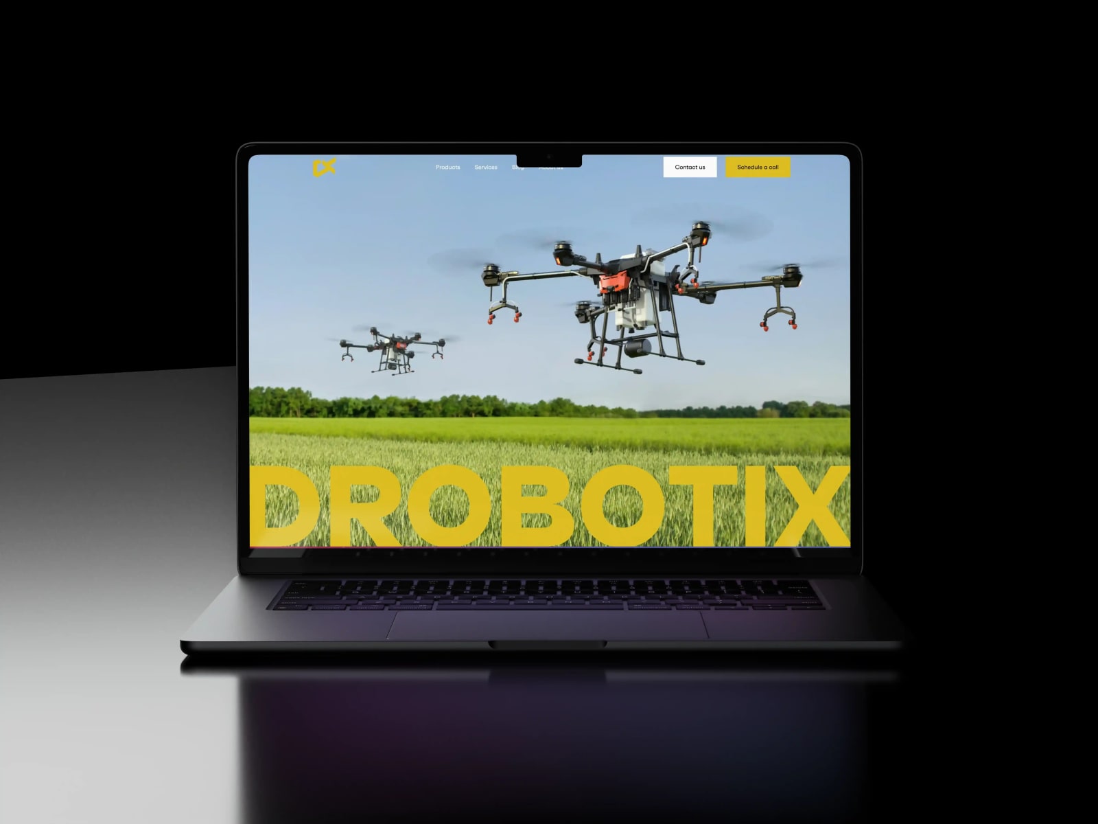 The Drobotix homepage on a laptop: a spraying drone over a field above the yellow DROBOTIX wordmark