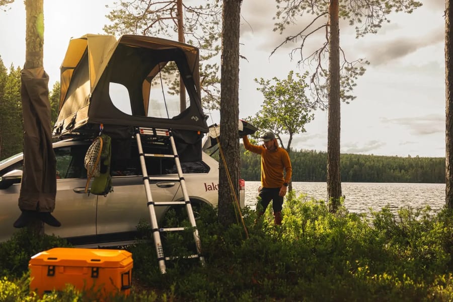 Biltelt ved et vann i skogen