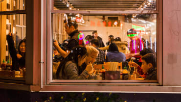 Seorang anak bersama dua orang dewasa menikmati makan malam di restoran Vietnam Pho Hung, Chinatown Toronto