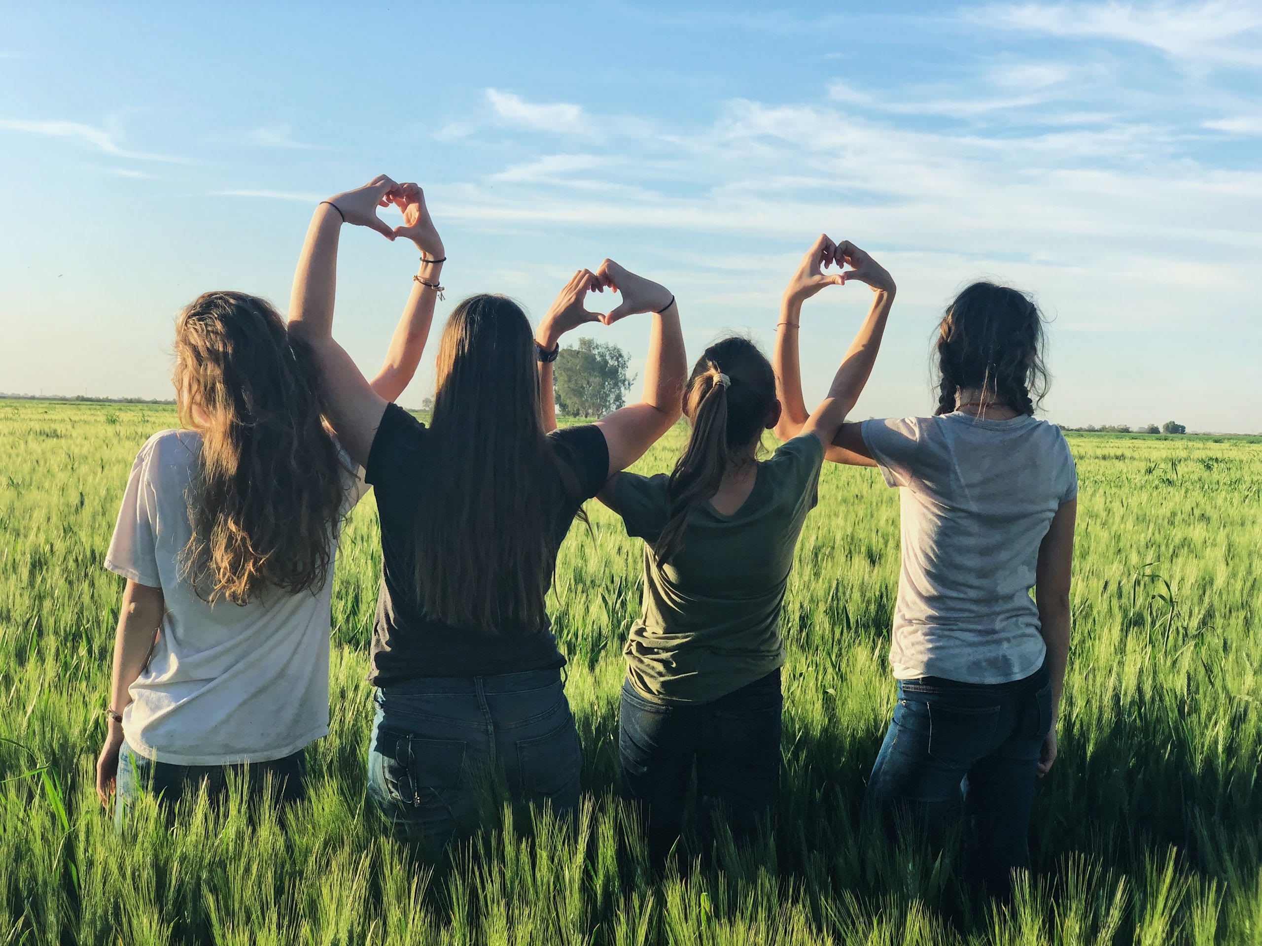 people making hearts in a field