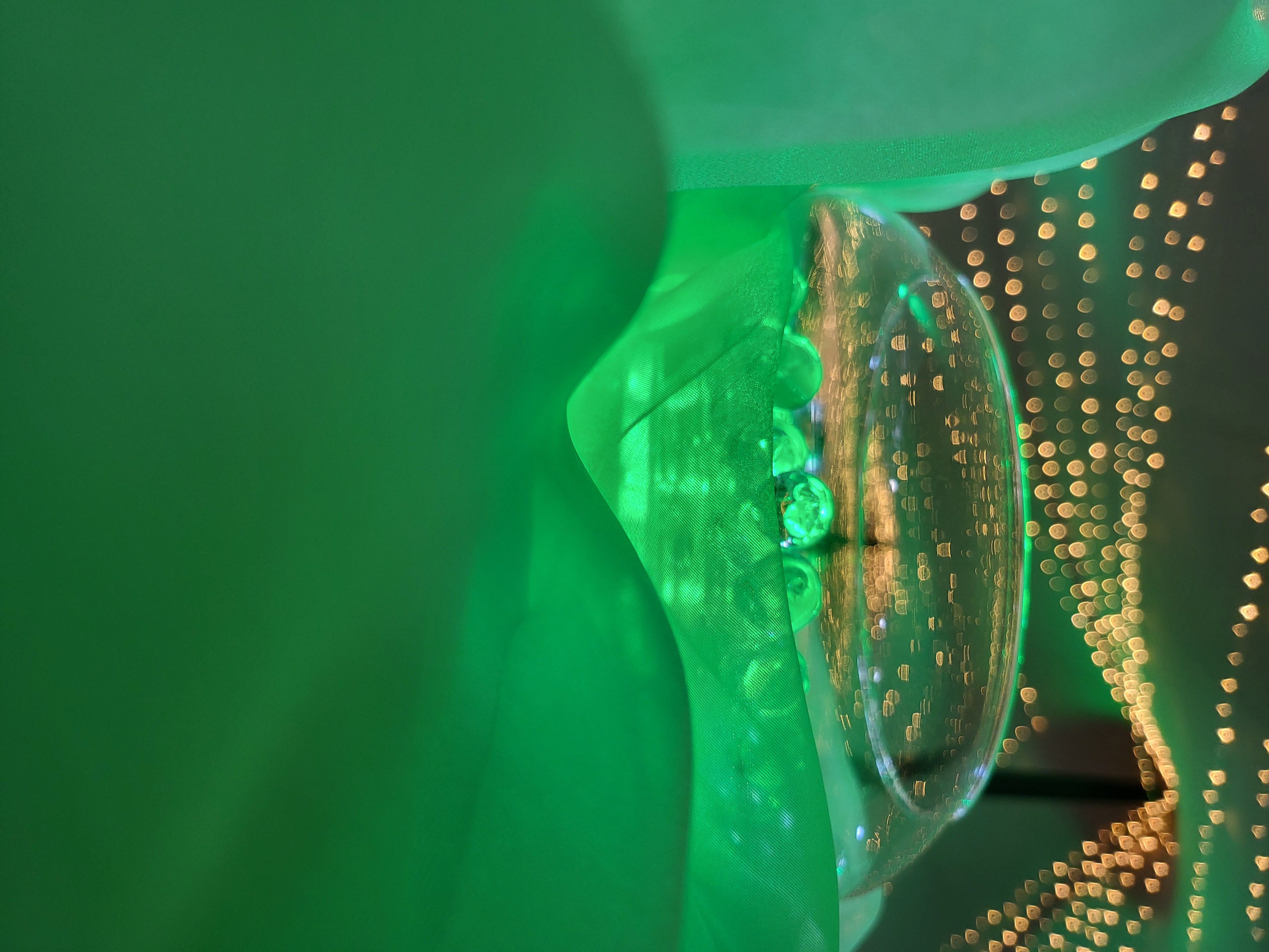 Glass bowl of gel beads set into folds of vivid green organza on a dark table