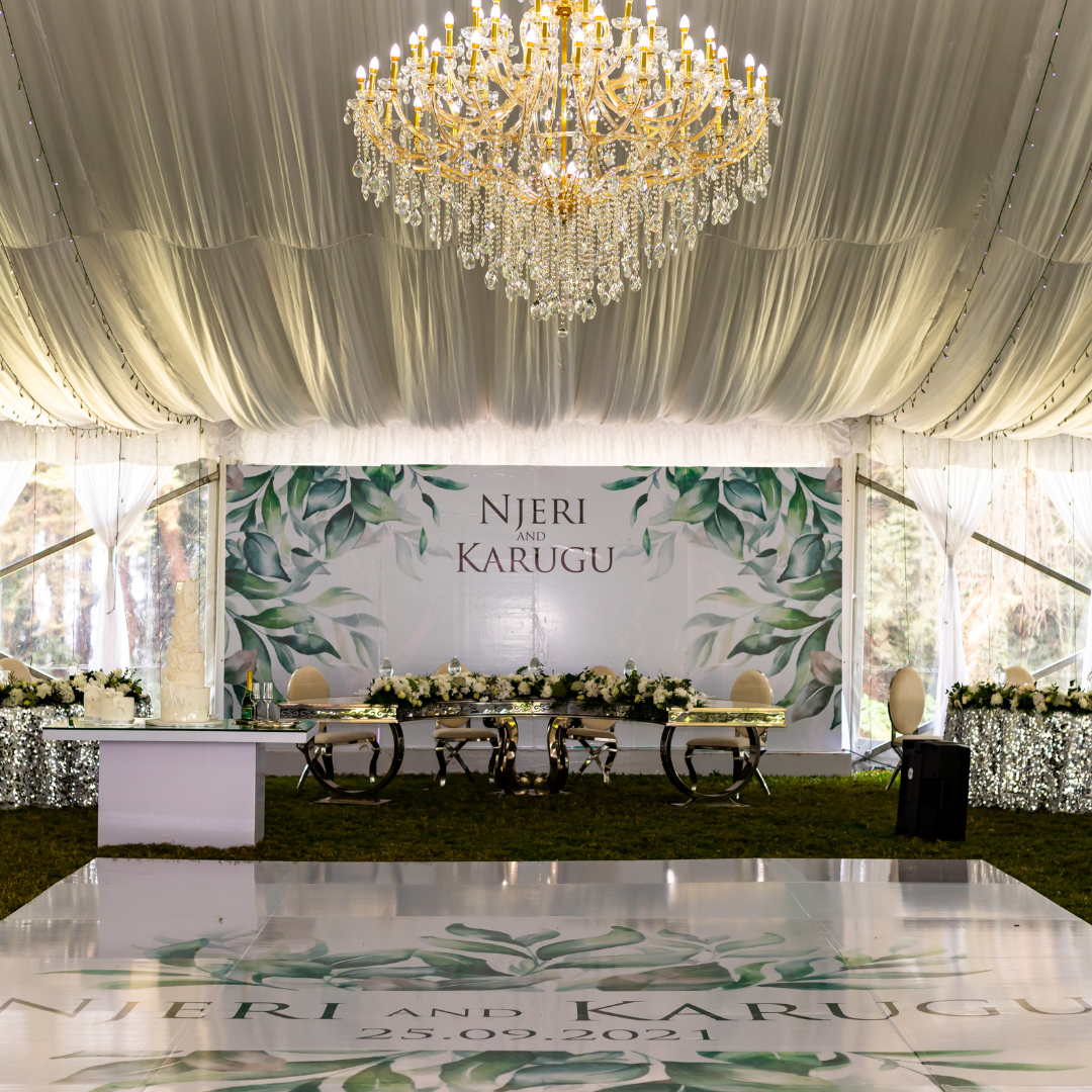 Garden wedding ceremony with a draped gazebo and floral aisle stands
