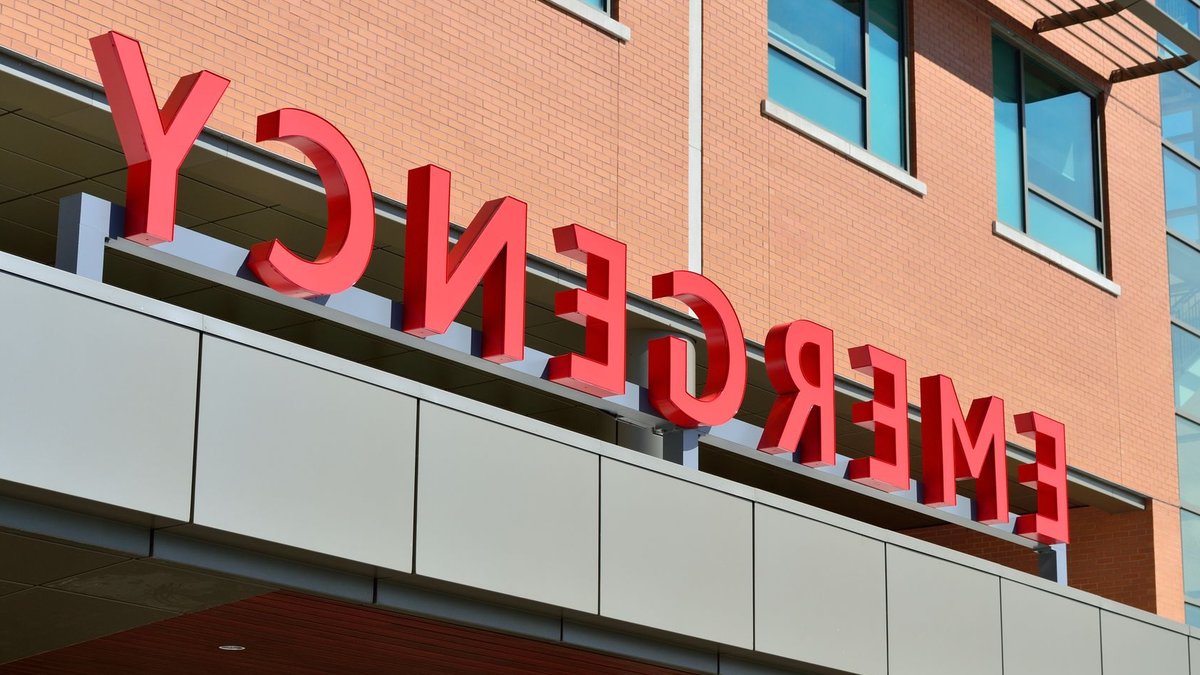 Close-up of a modern hospital emergency room entrance with prominent red letters.