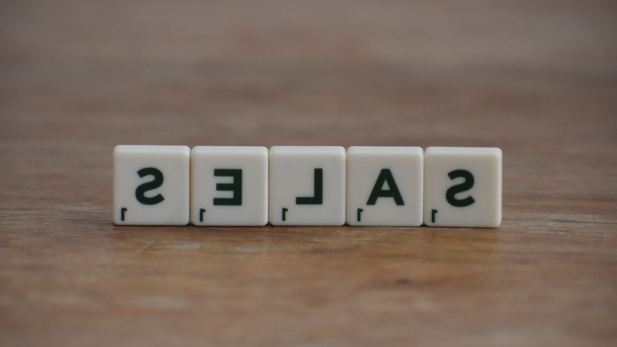 Attribution Problems Skew ROAS, Missing True Ad Impact Scrabble tiles spelling 'sales' on a wooden table, emphasizing business and marketing.