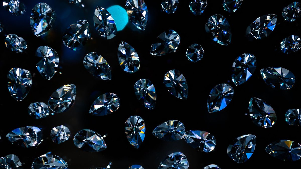 Glistening diamonds floating against a dark background, showcasing elegance and luxury.