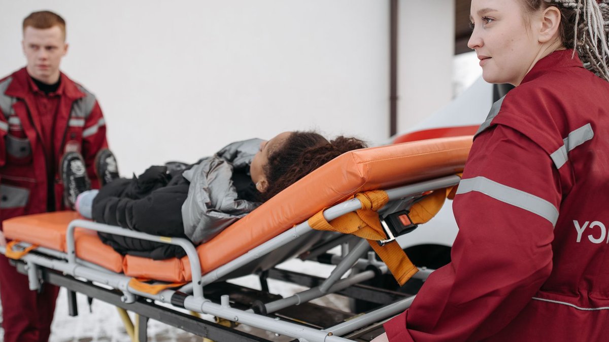 Free Ambulance Service Addresses Maternal Delays in Yobe Emergency responders assisting a patient on a stretcher, highlighting teamwork and medical care.
