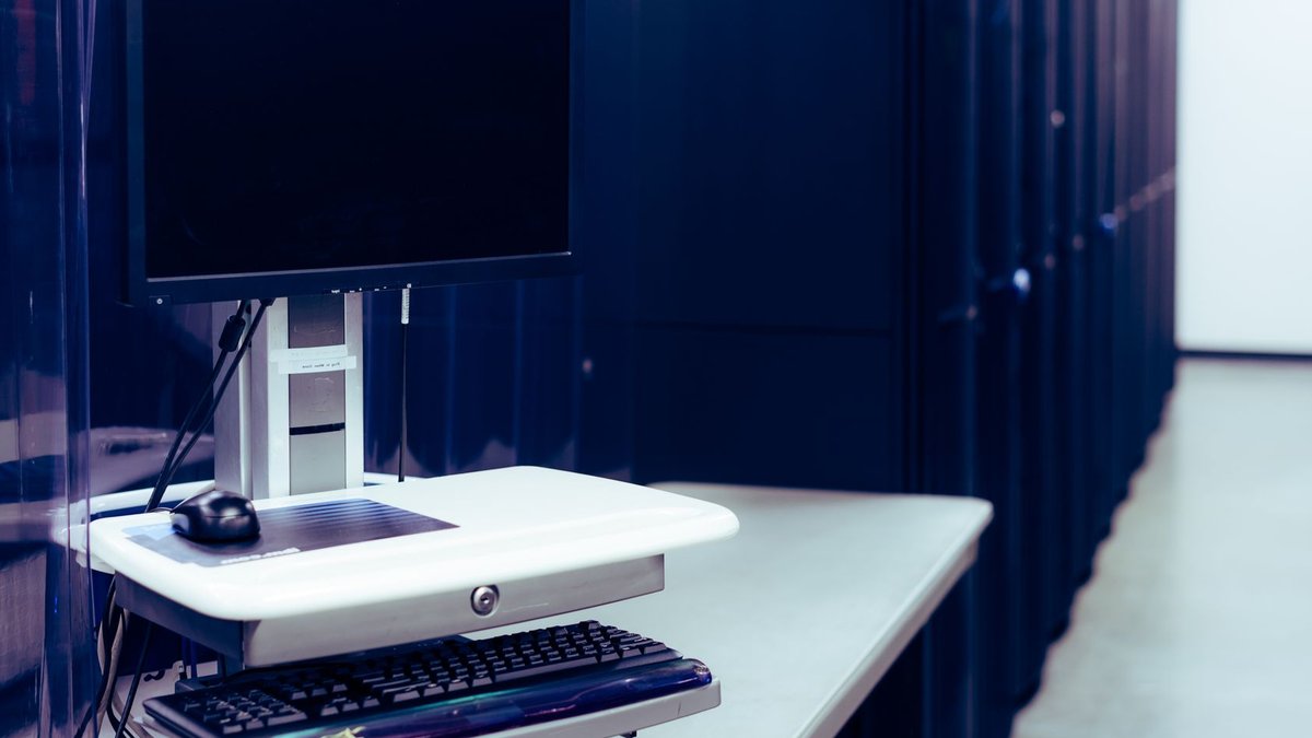 Park Place Launches AI Platform Scoring IT Hardware Contemporary computer with black screen placed on stand near row of server steel racks in data center.