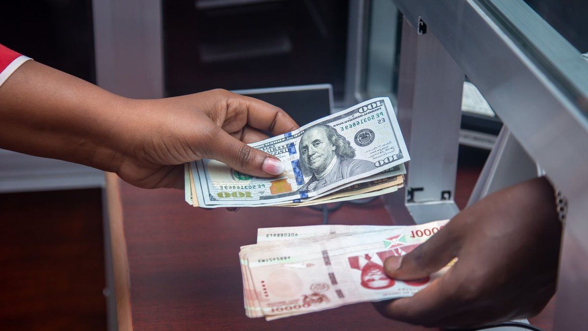 Bank of America launches seamless cross-border payments for businesses Hands exchanging US and local currency at a bank counter, signifying international finance.
