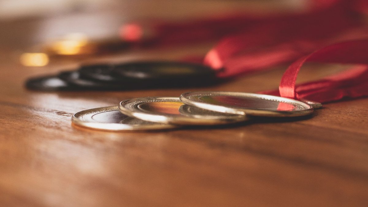 Close-up view of medals on a wooden table, showcasing bronze, silver, and gold awards.
