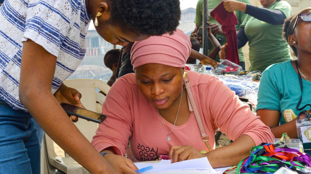 Group of volunteers working on registration at a community event outdoors.