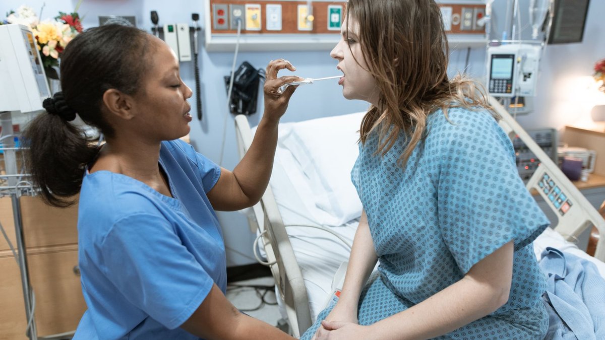 A nurse in scrubs caring for a patient in a hospital ward, demonstrating healthcare services.