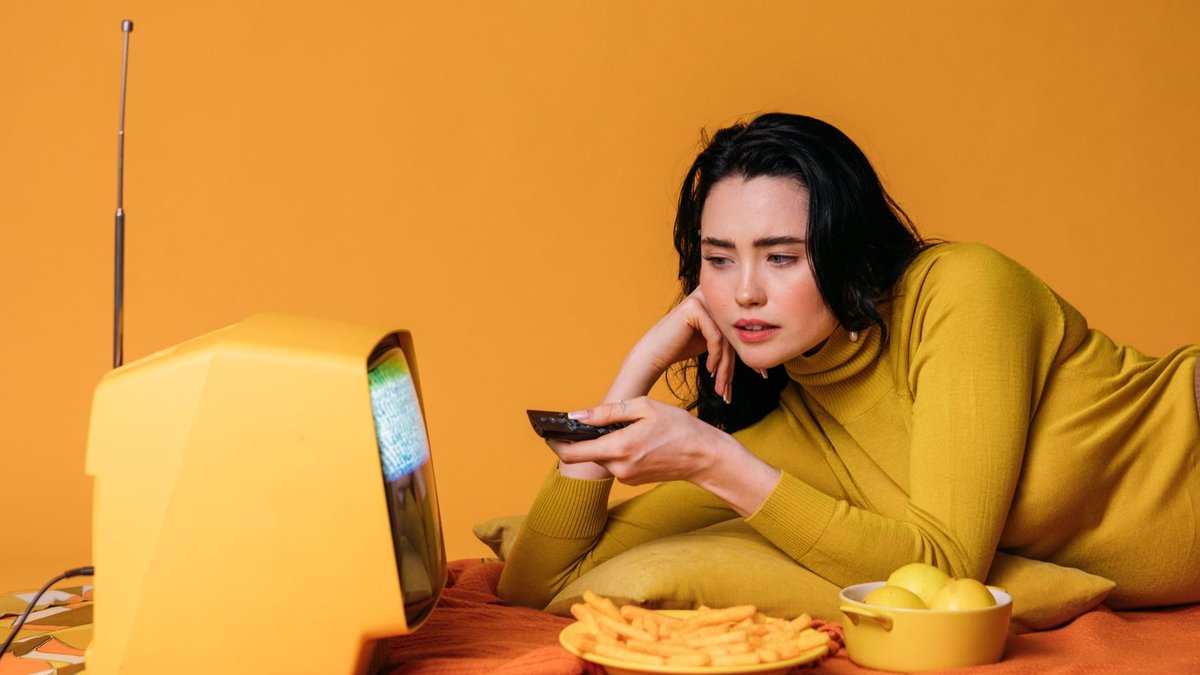Hisense U8 tops color tests, offers steep Prime Day discount Woman relaxing and watching a vintage television set while snacking on yellow chips.