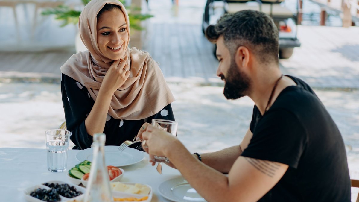 Smiling couple enjoying a lunch date outdoors, capturing love and connection.