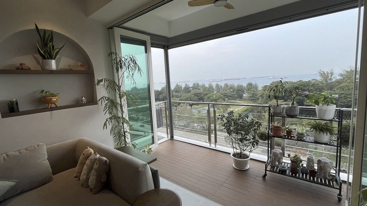 Budget-Conscious Family Renovates 4-Bedroom Home in Wabi-Sabi Style Apartment balcony with plants on rack and pots, sliding doors, cream sofa and built-in wall shelves.