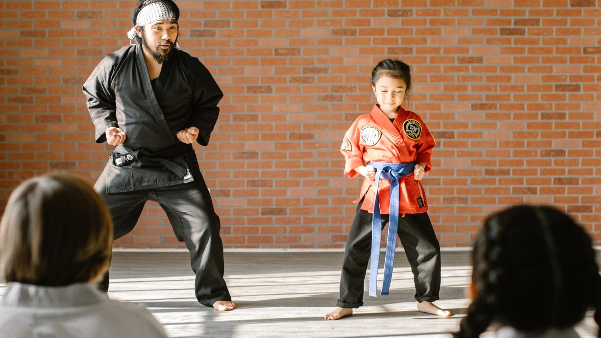 UK small businesses get instant access capital A martial arts instructor and a child student practicing karate in a dojo.