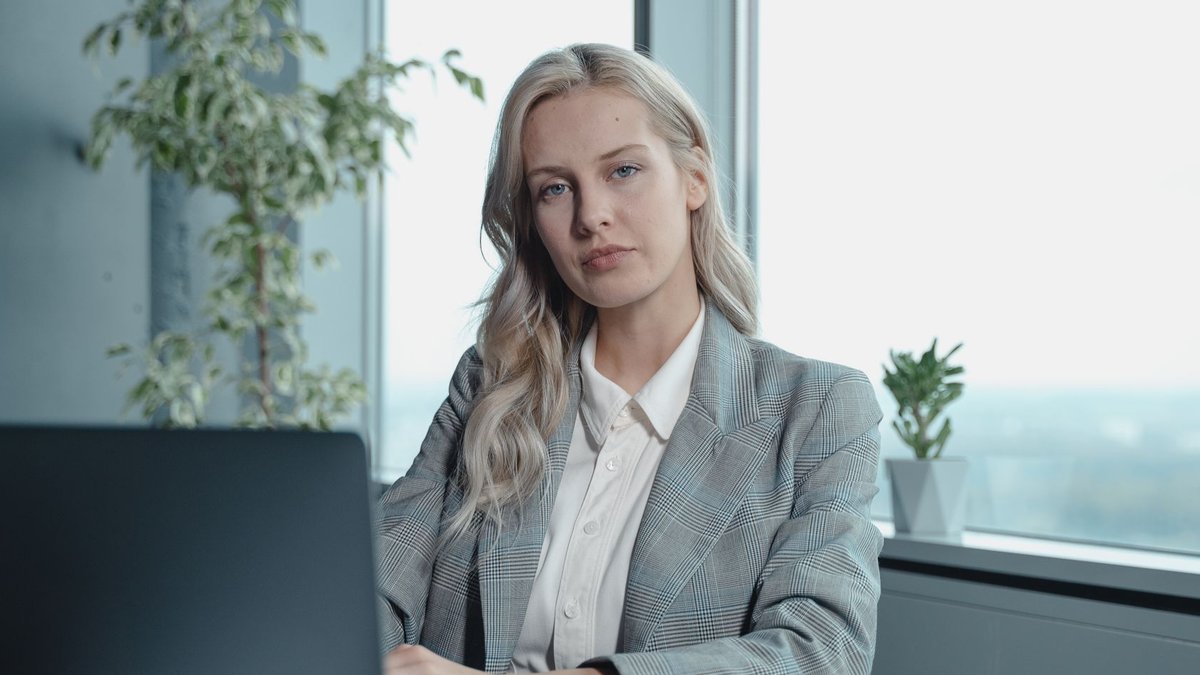 HR leader emphasizes integrity and courage Professional businesswoman at a desk in a bright office with a laptop and notebook.