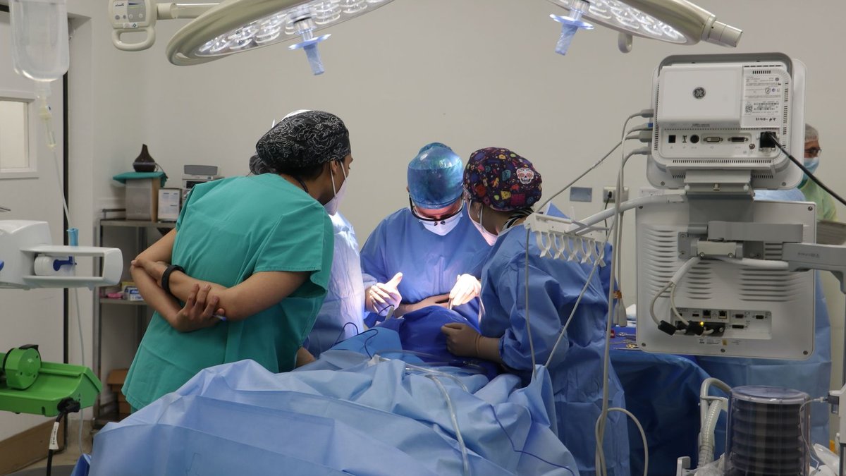 Team of surgeons operating in a well-equipped surgical room.