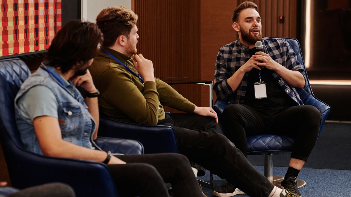 Group of young adults engaging in a lively panel discussion, fostering collaboration.