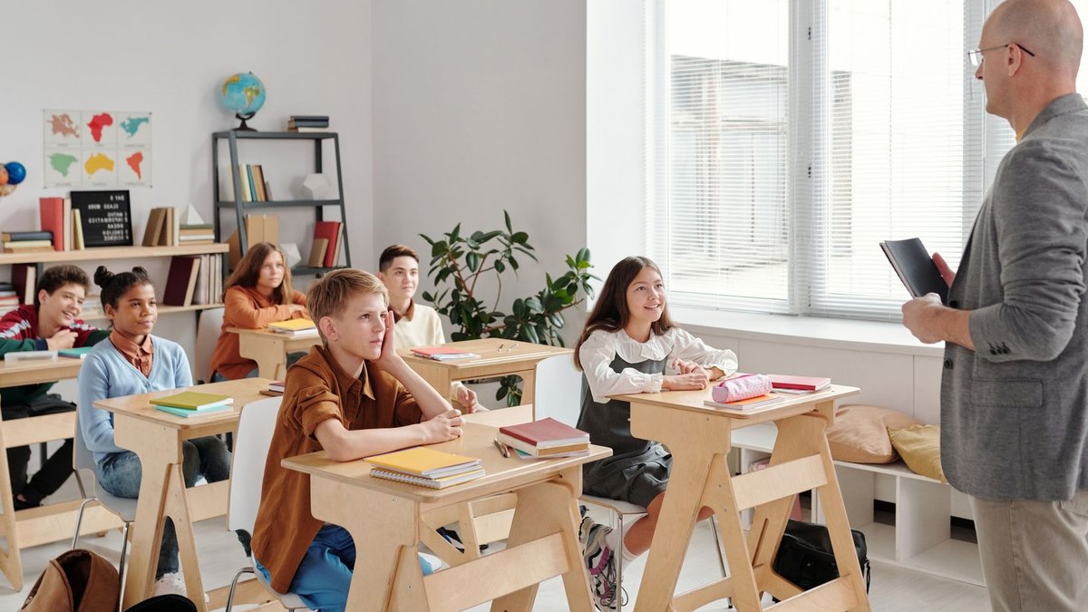A teacher conducting a lesson in a diverse, engaging classroom with attentive students.
