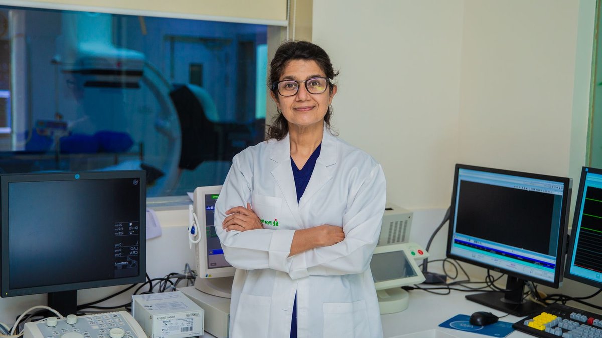 Confident female doctor with arms crossed in a modern medical laboratory setting in Delhi, India.