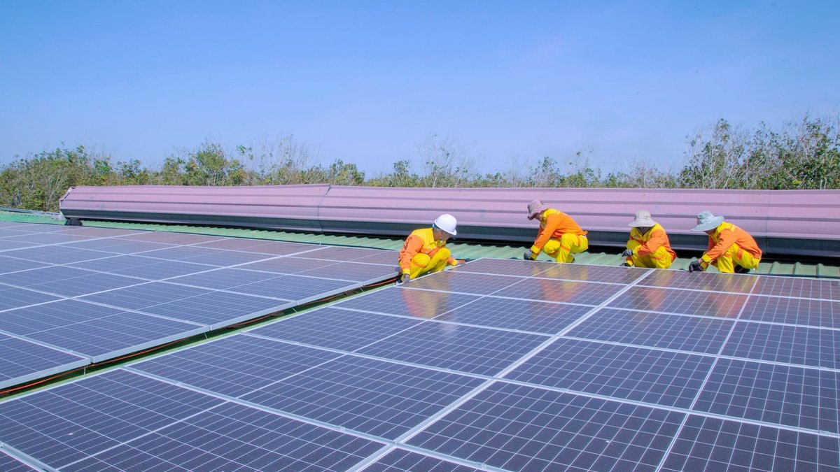 Workers installing solar panels on a sunny day, promoting renewable energy and sustainability.