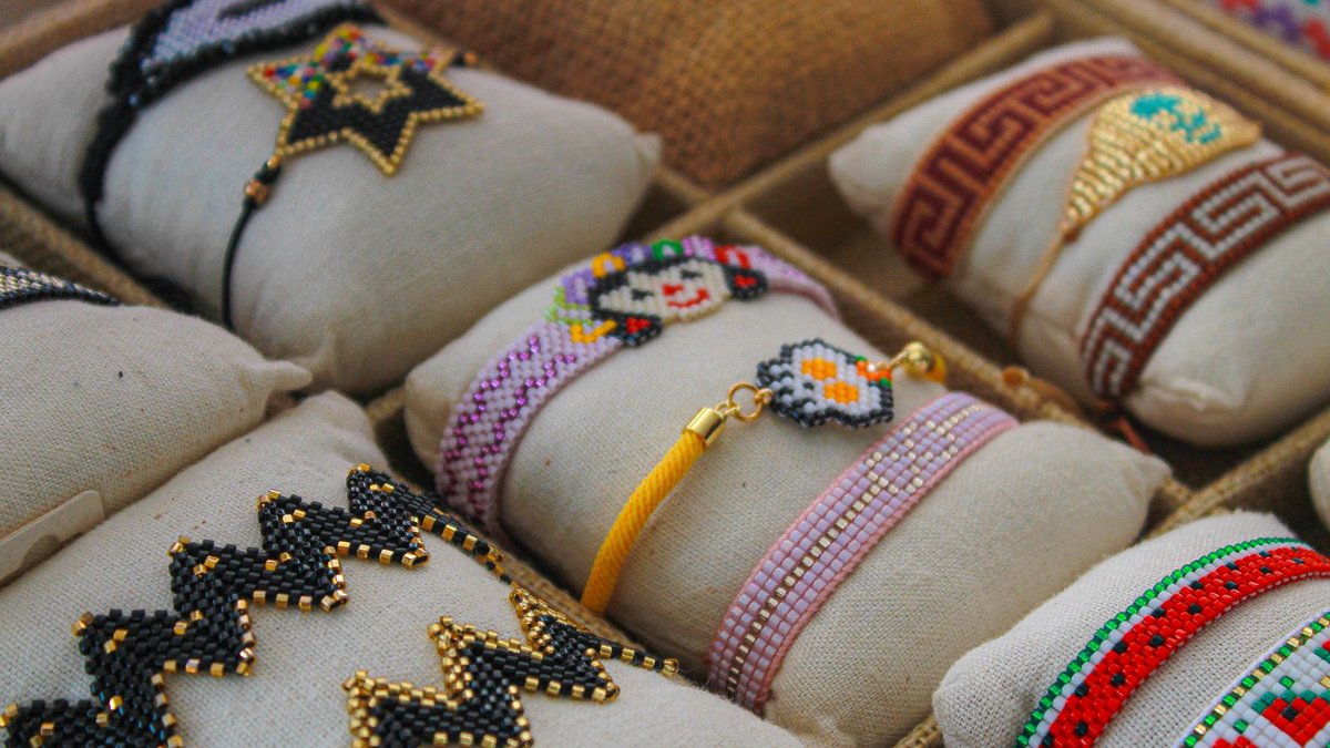 Close-up of vibrant handmade beaded bracelets in a market store display, showcasing intricate craftsmanship.