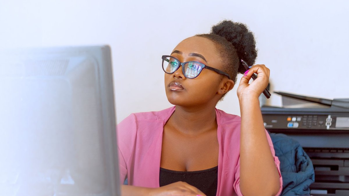 Kenya Bureau of Standards faces big deficit African woman in pink blouse working at her desk in an office with computer and printer.