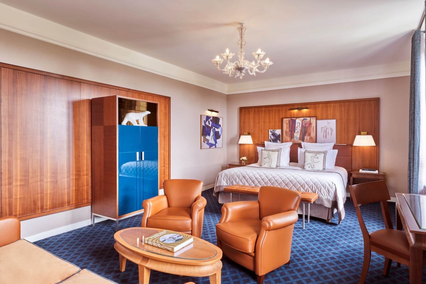 Una júnior suite de Le Westminster con paneles de madera y moqueta azul prusia