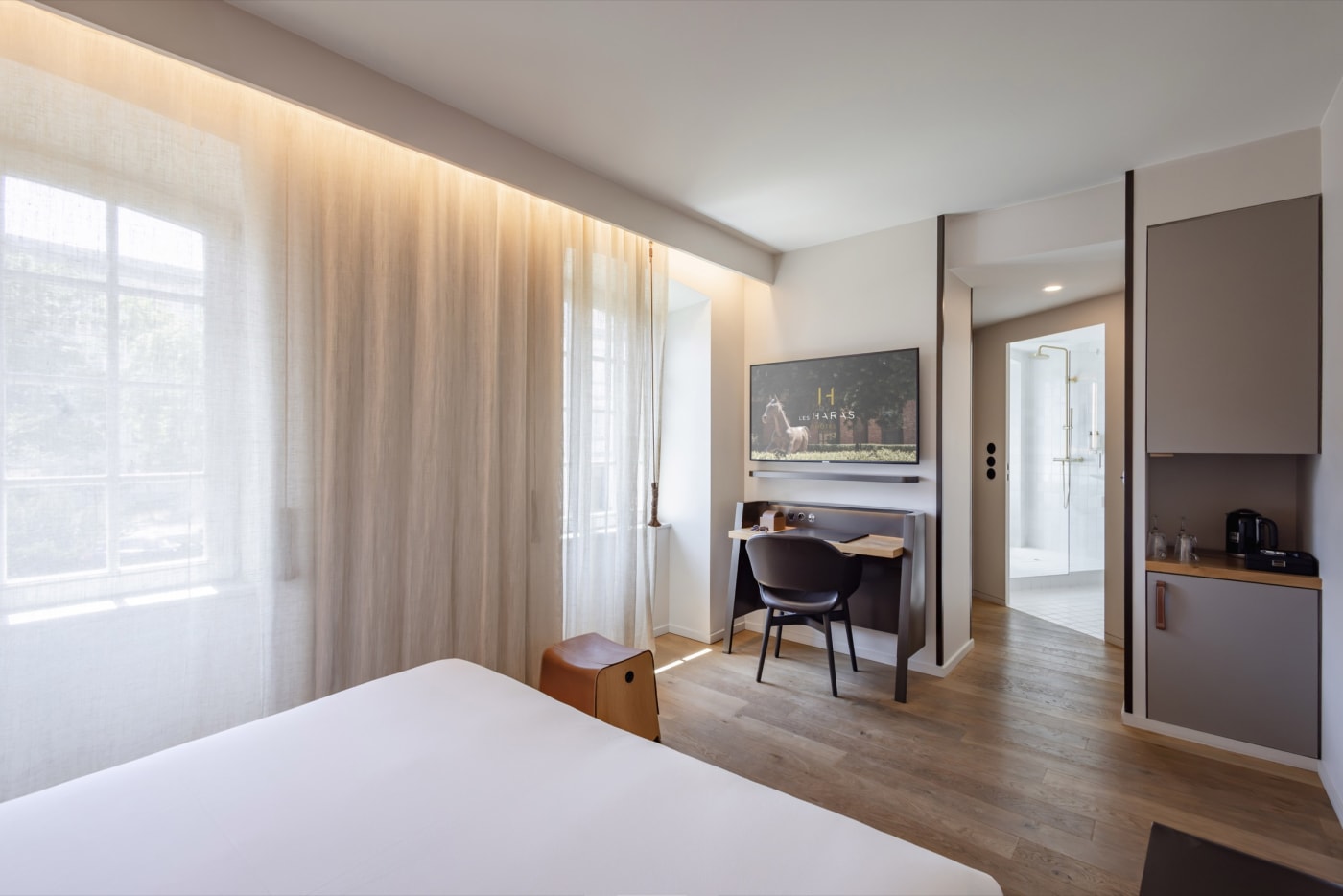 A Classic room at the hotel Les Haras, curved leather headboard