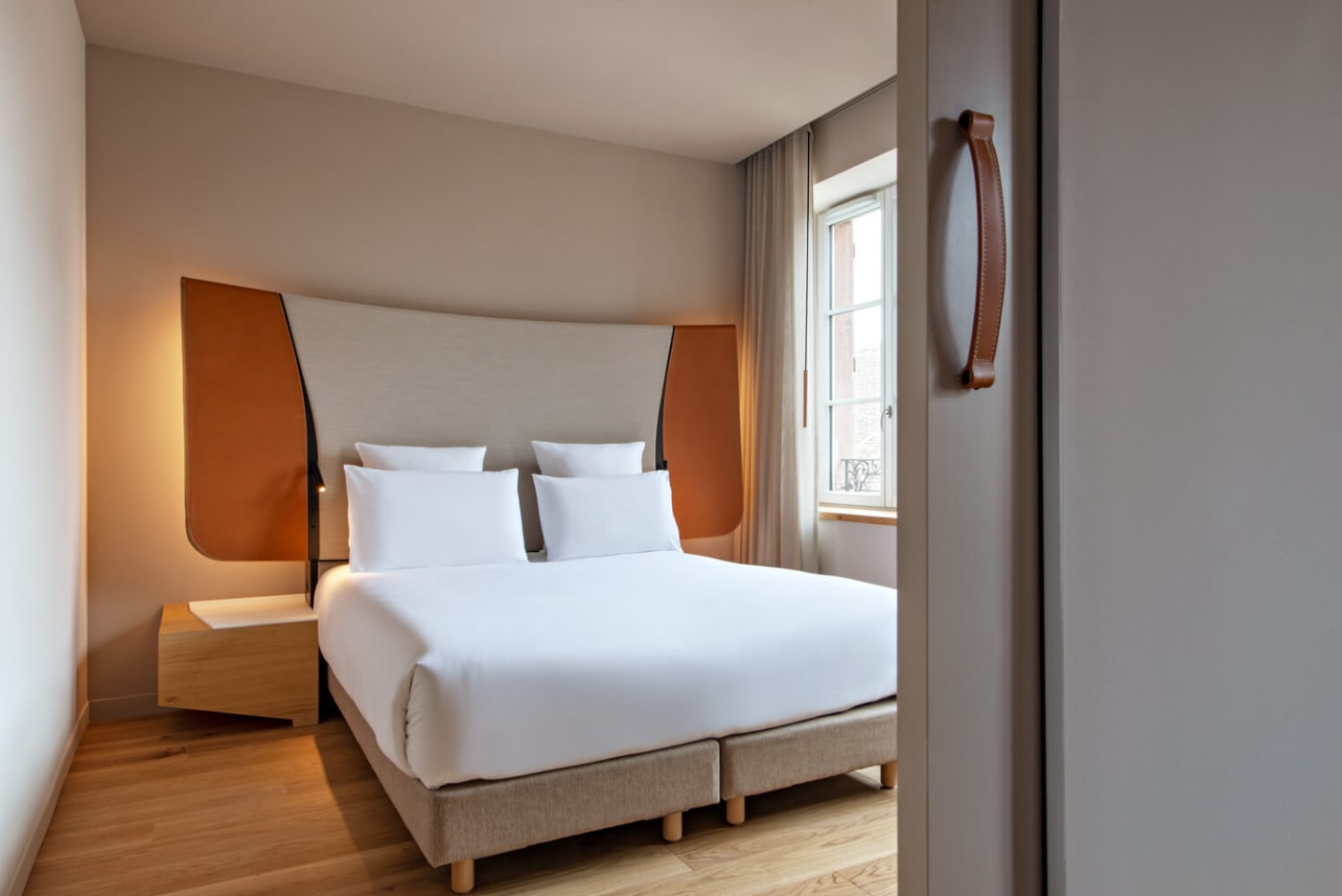The bedroom of a Suite at Les Haras, leather headboard