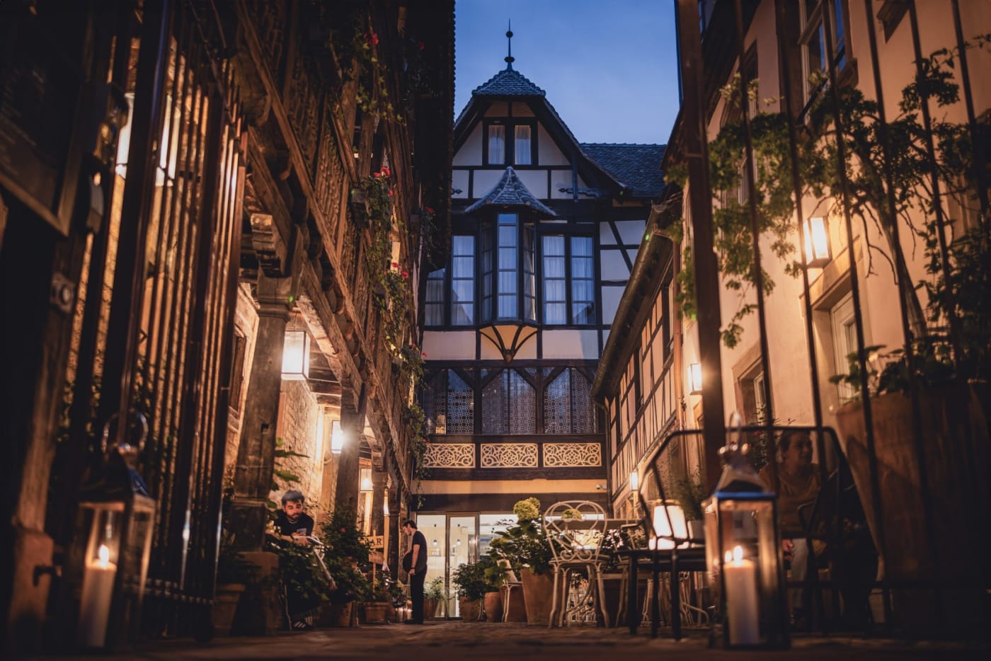 Der Renaissance-Innenhof des Hotels Cour du Corbeau bei Nacht beleuchtet