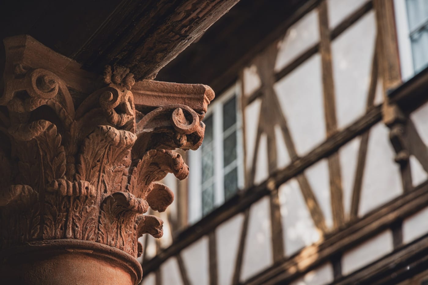 Ein geschnitztes Kapitell und Fachwerk des Cour du Corbeau