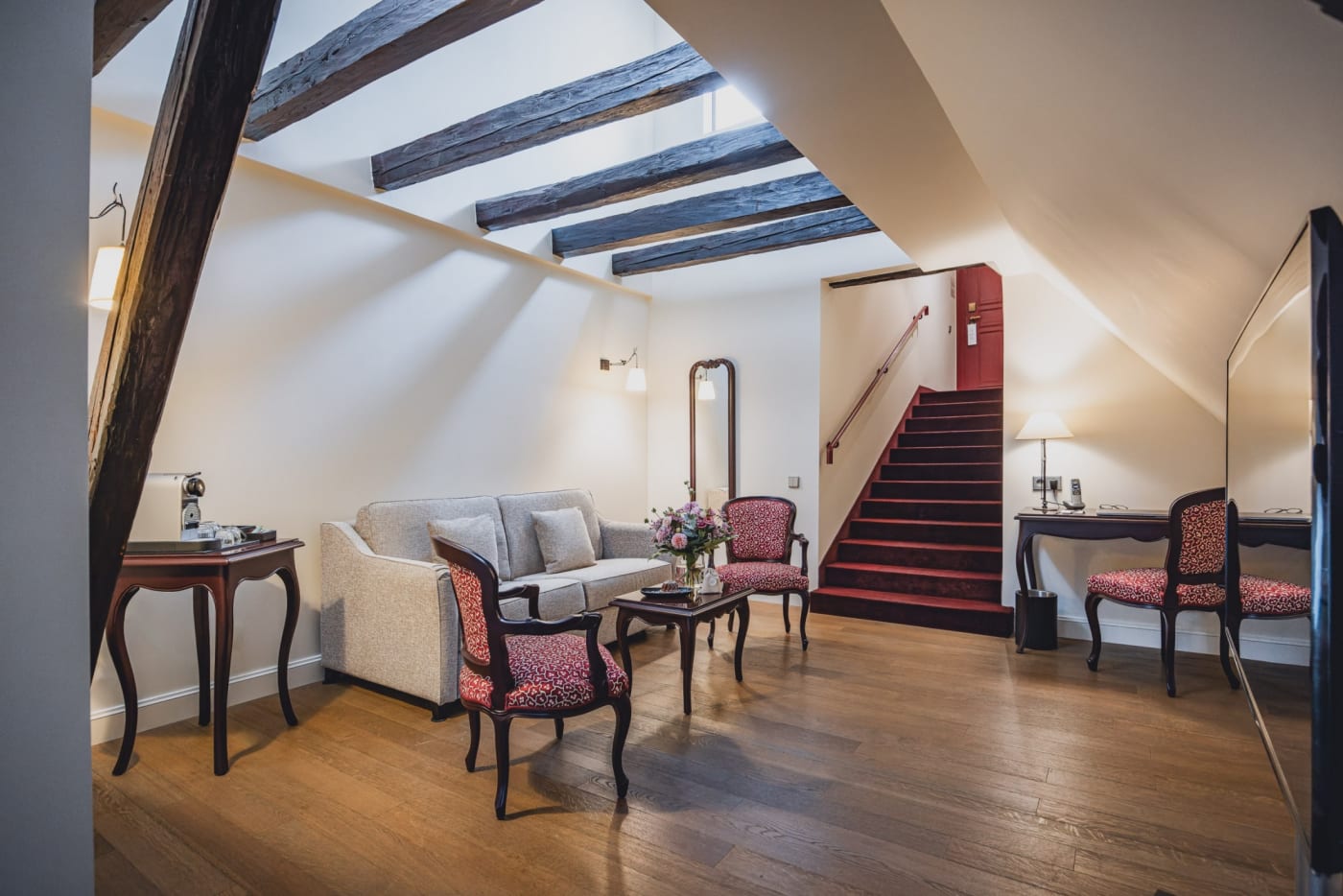 Das Wohnzimmer der Suite Authentique mit Sichtbalken im Cour du Corbeau