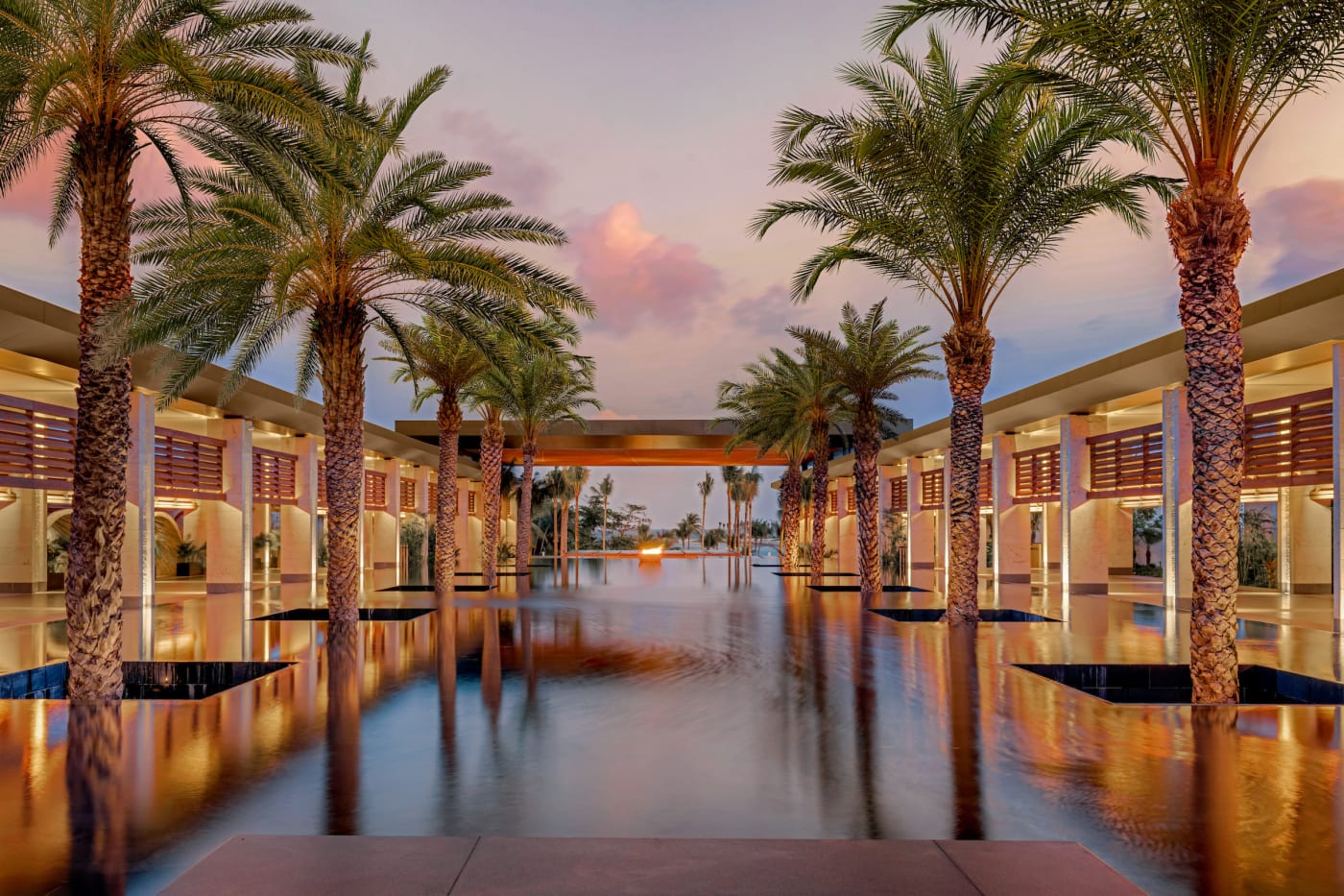 El vestíbulo de Conrad Tulum, piscina reflectante y palmeras