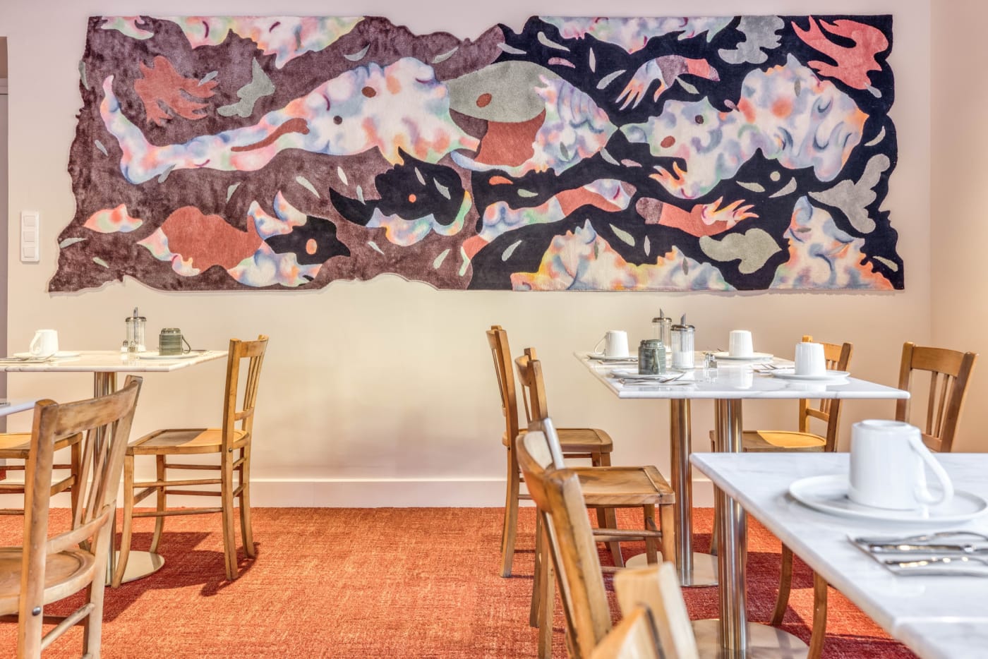 La sala de desayunos del hotel Le Lyret y su gran mural colorido