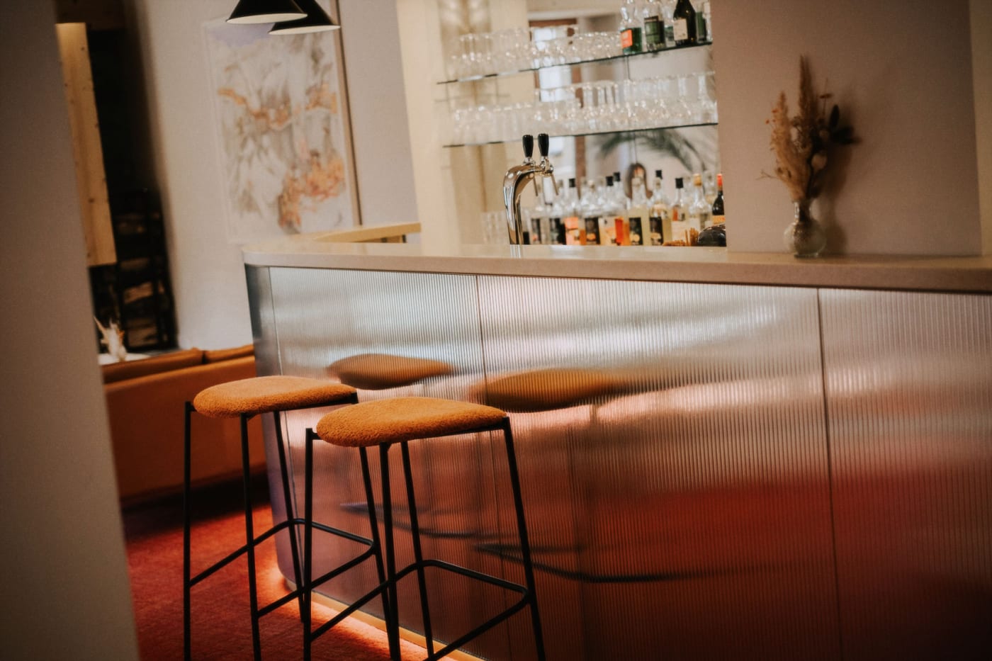 El bar del hotel Le Lyret en Chamonix, mostrador y taburetes anaranjados