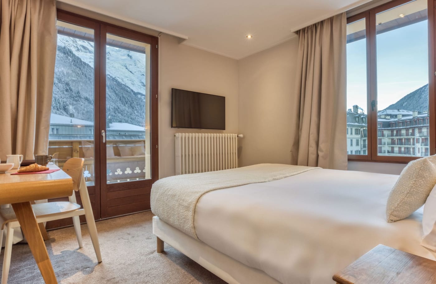 Una habitación doble con balcón y vistas a las montañas en el hotel Le Lyret