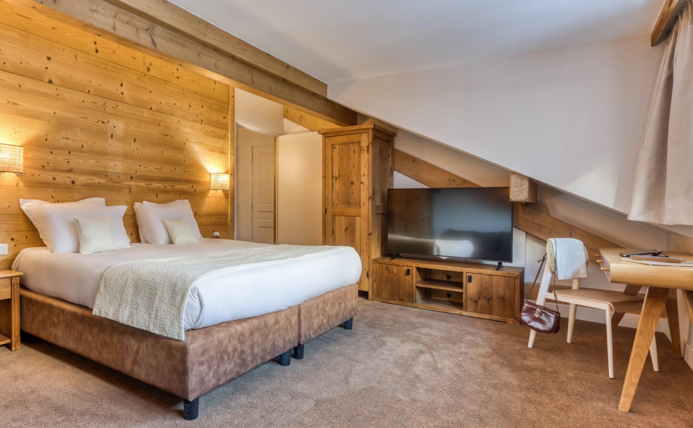 Una habitación doble de madera abuhardillada en el hotel Le Lyret